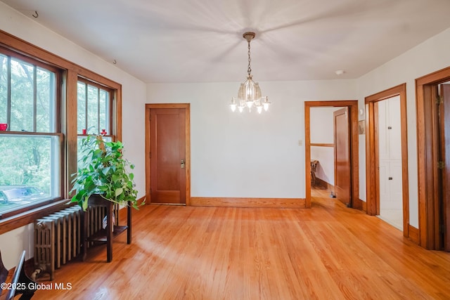 3063 Ny Highway 43, Sand Lake, NY 12018 - spare room featuring radiator, light wood-type flooring, and a chandelier