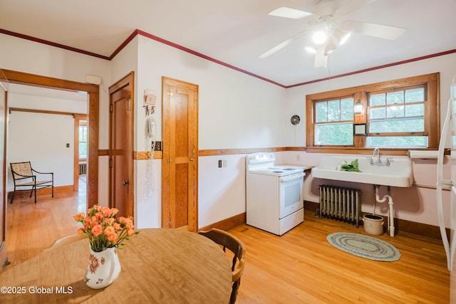3063 Ny Highway 43, Sand Lake, NY 12018 - laundry room with ornamental molding, light wood-style flooring, ceiling fan, and radiator heating unit