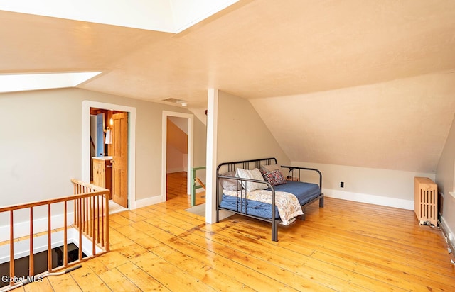 203 Center Rd, White Creek, NY 12057 - living area featuring an upstairs landing, radiator heating unit, hardwood / wood-style floors, lofted ceiling, and a skylight
