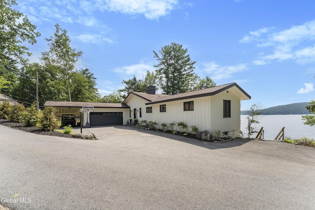 55 Trinity Rock Rd, Lake George, NY 12845 - view of front of property featuring an attached garage, a chimney, asphalt driveway, and board and batten siding