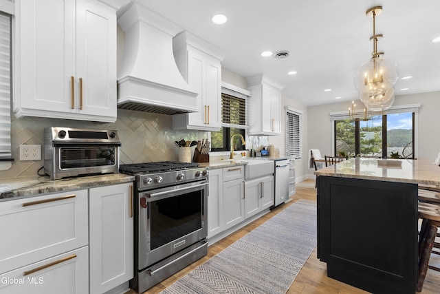 55 Trinity Rock Rd, Lake George, NY 12845 - kitchen featuring appliances with stainless steel finishes, custom range hood, backsplash, white cabinets, and light wood-style floors