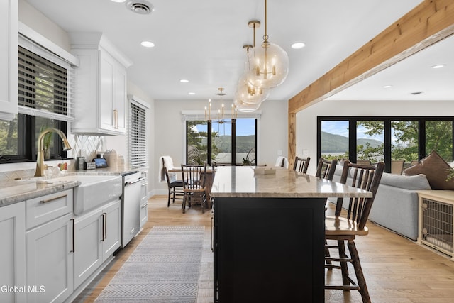 55 Trinity Rock Rd, Lake George, NY 12845 - kitchen with dishwasher, a chandelier, a kitchen breakfast bar, light stone counters, and decorative light fixtures