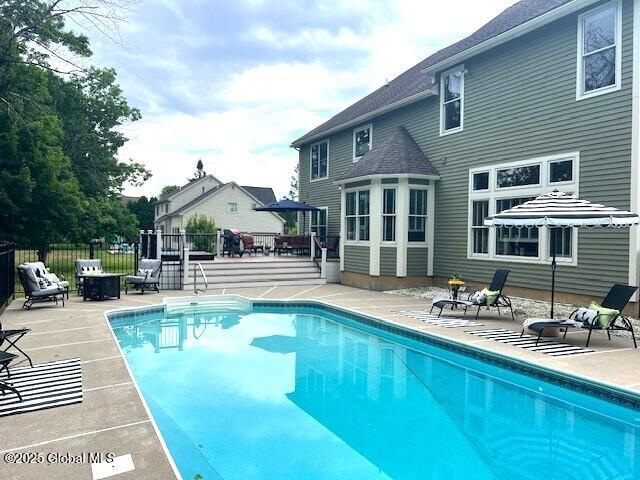 96 Masters Cmn N, Queensbury, NY 12804 - view of swimming pool featuring a deck and a patio