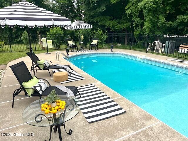 96 Masters Cmn N, Queensbury, NY 12804 - view of swimming pool with a patio area and view of wooded area