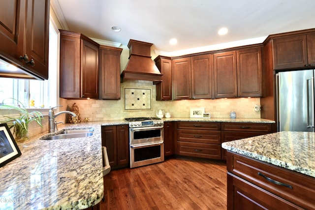 96 Masters Cmn N, Queensbury, NY 12804 - kitchen featuring appliances with stainless steel finishes, custom exhaust hood, light stone countertops, dark wood finished floors, and tasteful backsplash