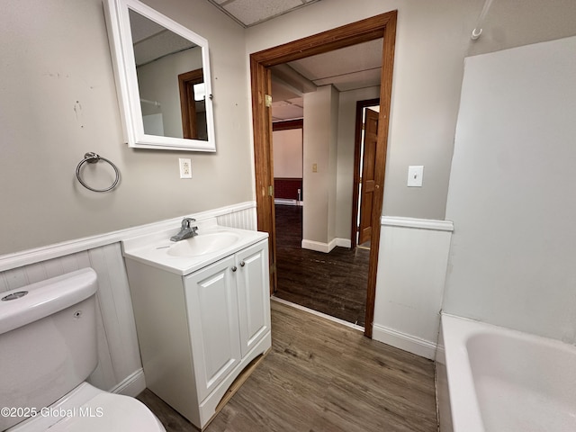 1 S Main St, Voorheesville, NY 12186 - bathroom featuring a wainscoted wall, wood finished floors, vanity, and a tub to relax in