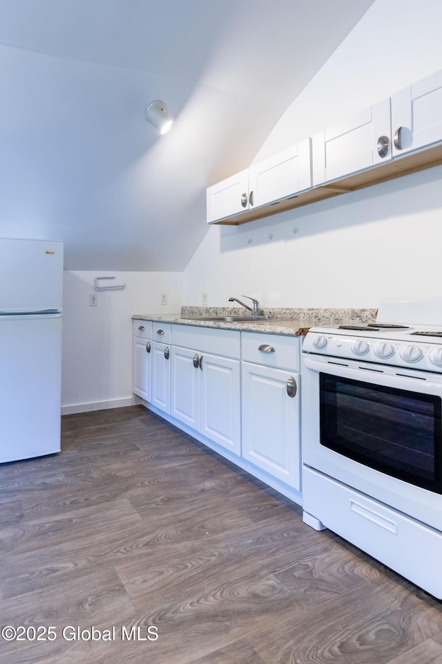 17564 State Route 22, Berlin, NY 12022 - kitchen with white appliances, vaulted ceiling, white cabinetry, dark wood-style flooring, and light stone countertops