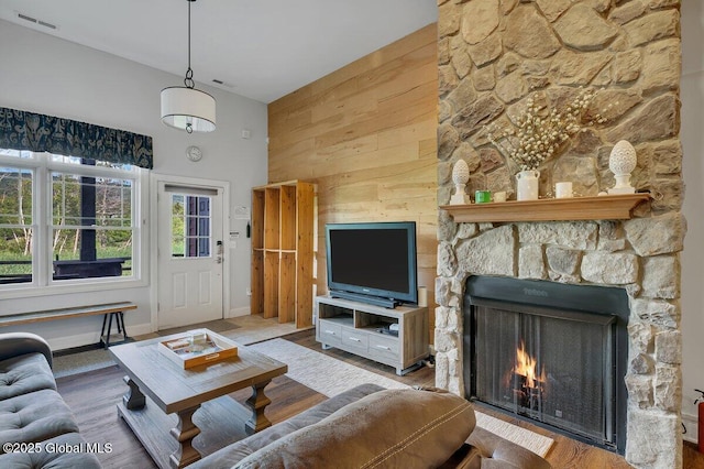 8 Trailside Dr Unit B10, Hunter, NY 12442 - living room with a stone fireplace, wooden walls, wood finished floors, and a towering ceiling