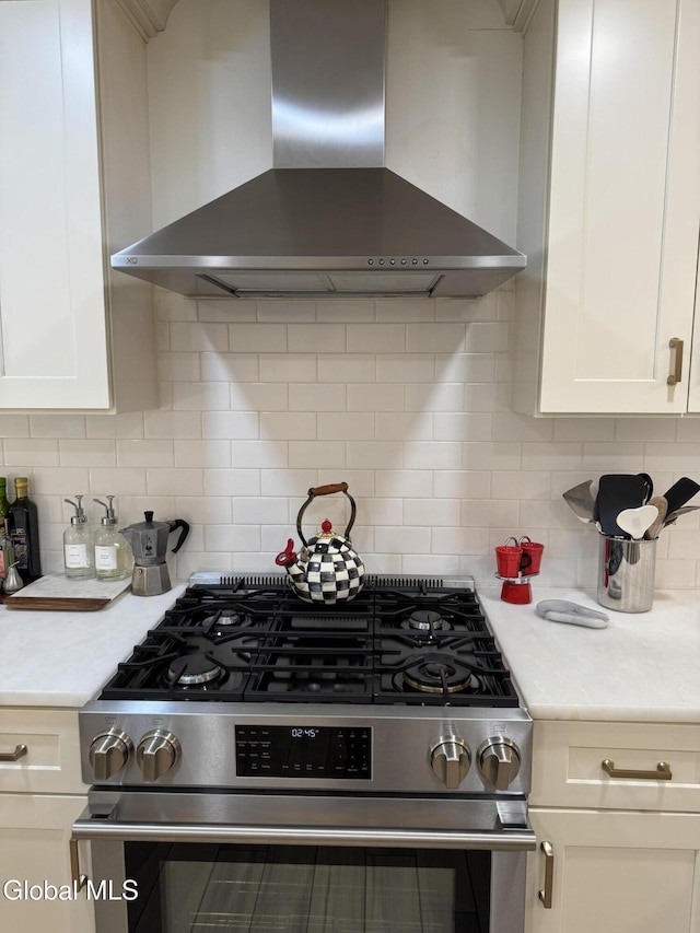 32 Winnie St, Albany, NY 12208 - kitchen with wall chimney exhaust hood, stainless steel range with gas cooktop, light countertops, and white cabinets