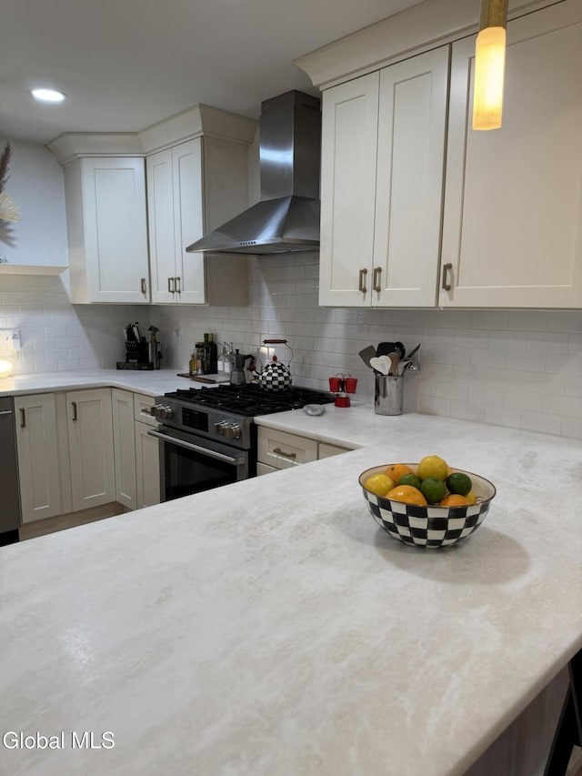 32 Winnie St, Albany, NY 12208 - kitchen with wall chimney range hood, appliances with stainless steel finishes, light countertops, decorative backsplash, and white cabinetry
