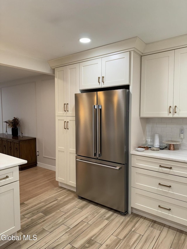 32 Winnie St, Albany, NY 12208 - kitchen with high end fridge, light wood-style floors, light countertops, decorative backsplash, and white cabinets