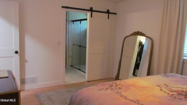 32 Winnie St, Albany, NY 12208 - bedroom featuring a barn door, ensuite bath, and wood finished floors