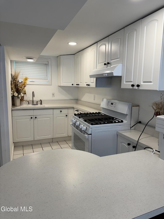 32 Winnie St, Albany, NY 12208 - kitchen with under cabinet range hood, gas range gas stove, white cabinets, light countertops, and recessed lighting