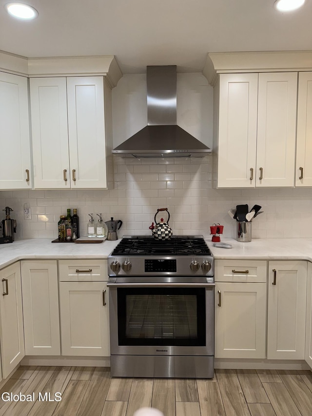 32 Winnie St, Albany, NY 12208 - kitchen with wall chimney exhaust hood, stainless steel gas stove, white cabinets, light countertops, and recessed lighting