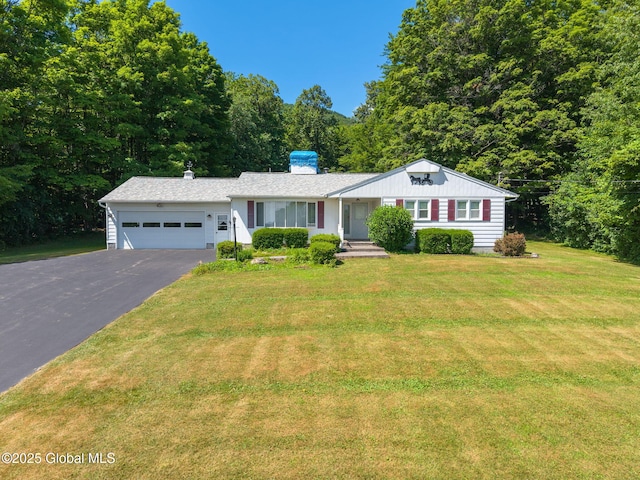 921 Altamont Voorheesville Rd, Altamont, NY 12009 - ranch-style house with an attached garage, asphalt driveway, a front lawn, a chimney, and a view of trees