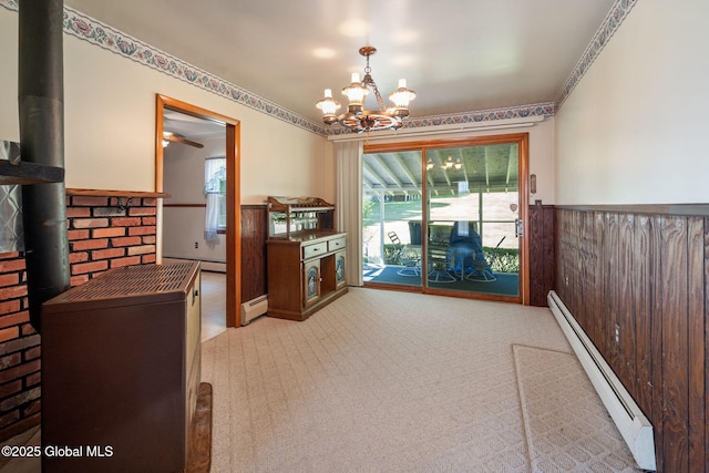 921 Altamont Voorheesville Rd, Altamont, NY 12009 - unfurnished dining area featuring a baseboard radiator, a wood stove, carpet floors, and wainscoting