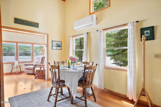 2235 Oaks Rd, Argyle, NY 12809 - dining area featuring an AC wall unit, wood finished floors, a high ceiling, and a water view