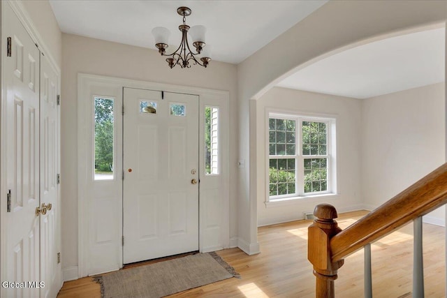 3 Lucille Ln, Malta, NY 12019 - foyer with arched walkways, light wood-style flooring, and a chandelier