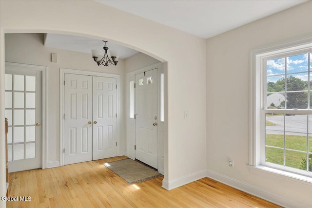 3 Lucille Ln, Malta, NY 12019 - foyer with arched walkways, a chandelier, plenty of natural light, and light wood-style flooring