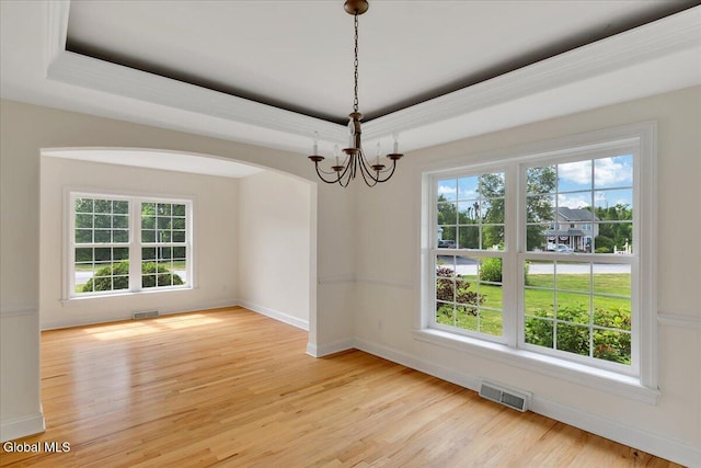 3 Lucille Ln, Malta, NY 12019 - empty room featuring a chandelier, light wood-style flooring, arched walkways, and a raised ceiling