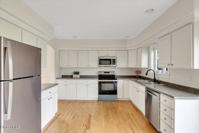 3 Lucille Ln, Malta, NY 12019 - kitchen with appliances with stainless steel finishes, dark countertops, white cabinets, and light wood-style floors