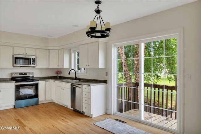 3 Lucille Ln, Malta, NY 12019 - kitchen with appliances with stainless steel finishes, dark countertops, a chandelier, and white cabinetry