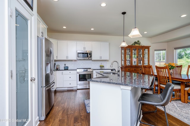 55 Winterberry Ln, Moreau, NY 12828 - kitchen with appliances with stainless steel finishes, dark stone counters, tasteful backsplash, a breakfast bar, and recessed lighting