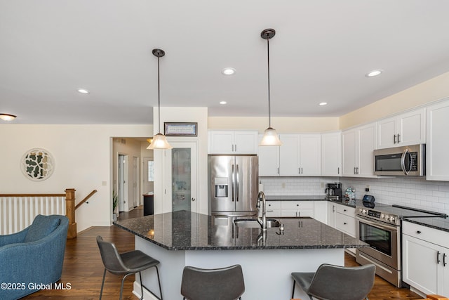 55 Winterberry Ln, Moreau, NY 12828 - kitchen with appliances with stainless steel finishes, backsplash, a kitchen breakfast bar, white cabinetry, and recessed lighting