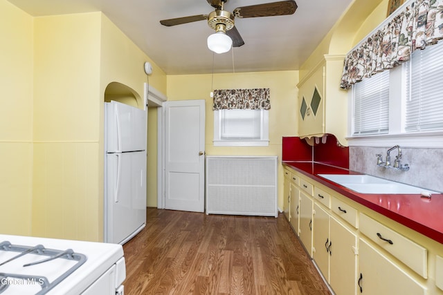 1633 Chrisler Ave, Schenectady, NY 12303 - kitchen featuring white appliances, radiator, ceiling fan, wood finished floors, and a wainscoted wall