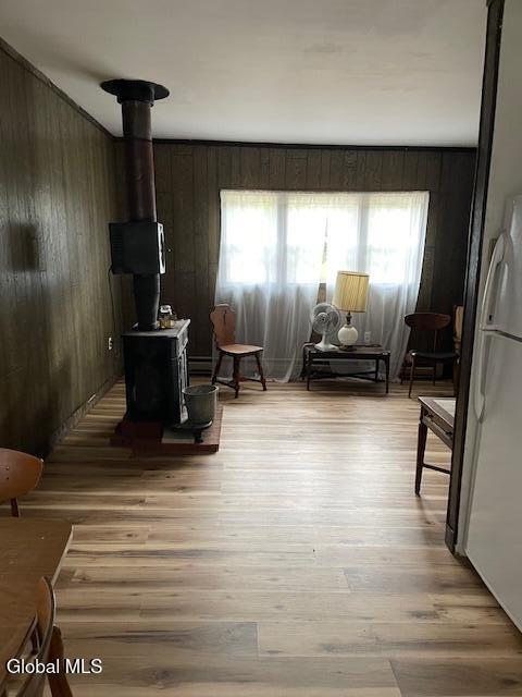 129 Moan And Groan Rd, Hope, NY 12134 - sitting room with wooden walls, plenty of natural light, light wood-style floors, and a wood stove