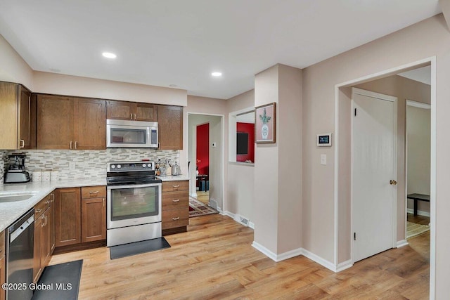 15 Deer Path Dr, Colonie, NY 12205 - kitchen featuring stainless steel appliances, light countertops, tasteful backsplash, light wood-type flooring, and recessed lighting
