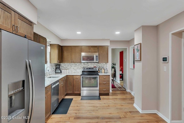 15 Deer Path Dr, Colonie, NY 12205 - kitchen with stainless steel appliances, backsplash, light wood-style floors, recessed lighting, and brown cabinetry