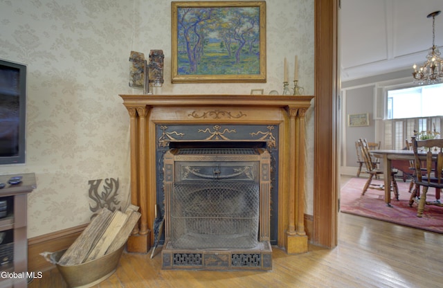 202 W 1st Ave, Johnstown, NY 12095 - detailed view of wood finished floors, a fireplace, a chandelier, and wallpapered walls