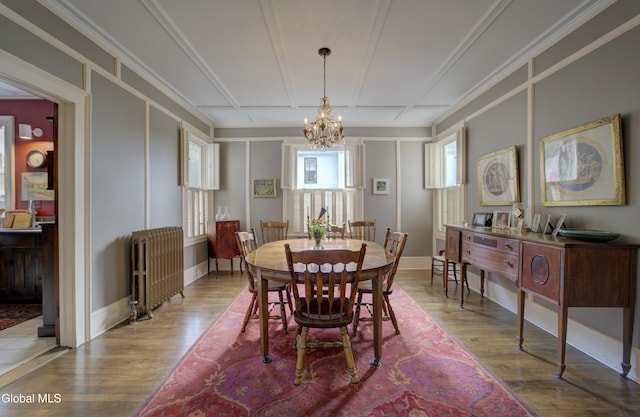 202 W 1st Ave, Johnstown, NY 12095 - dining area with radiator heating unit, a chandelier, and wood finished floors