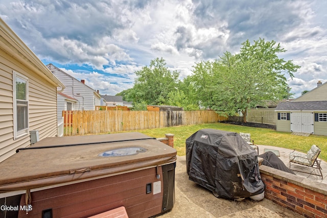 2834 Halsey Dr, Schenectady, NY 12304 - fenced backyard featuring a hot tub, a grill, an outbuilding, and a patio area
