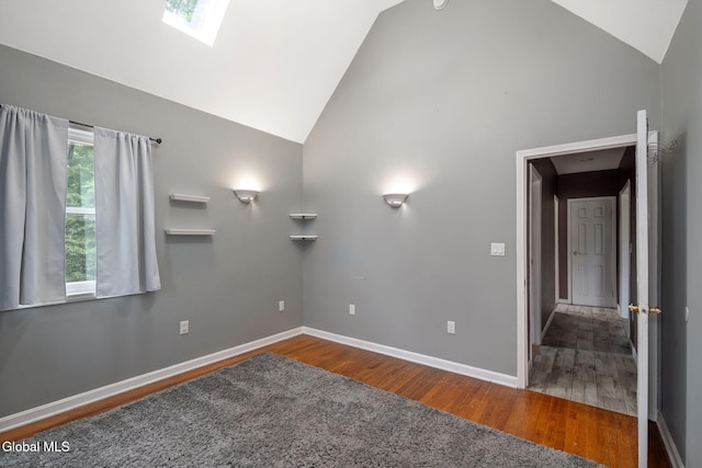 654 Sand Creek Rd, Colonie, NY 12205 - spare room featuring high vaulted ceiling, wood finished floors, and a skylight
