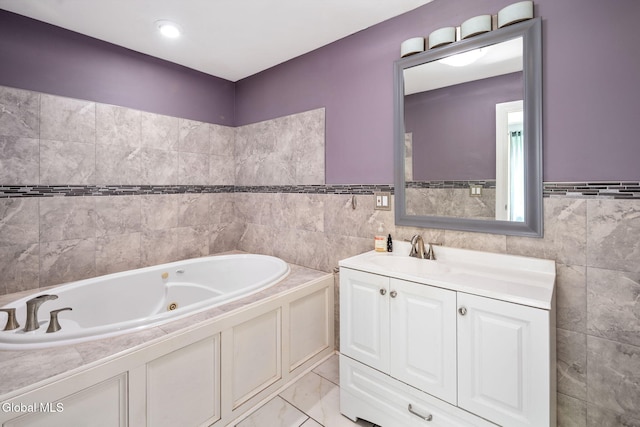 654 Sand Creek Rd, Colonie, NY 12205 - full bathroom with tile walls, a whirlpool tub, vanity, a wainscoted wall, and marble look tile flooring
