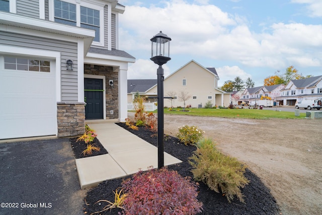 47 Priddle Ln, Colonie, NY 12110 - property entrance featuring stone siding, a residential view, and a garage