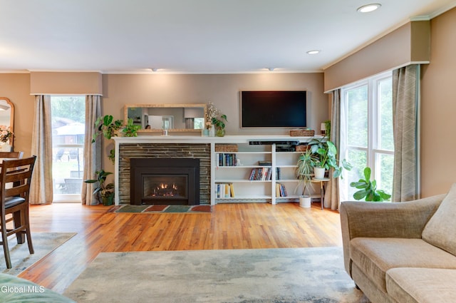 909 Ash Tree Ln, Niskayuna, NY 12309 - living area with wood finished floors, healthy amount of natural light, crown molding, a fireplace with flush hearth, and recessed lighting