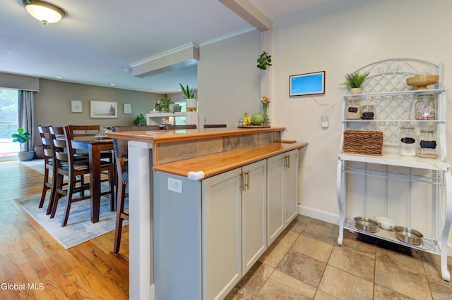 909 Ash Tree Ln, Niskayuna, NY 12309 - kitchen featuring a peninsula, white cabinetry, ornamental molding, and light countertops