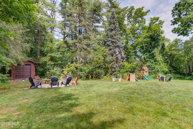 909 Ash Tree Ln, Niskayuna, NY 12309 - view of green lawn featuring a playground, an outdoor fire pit, and an outbuilding