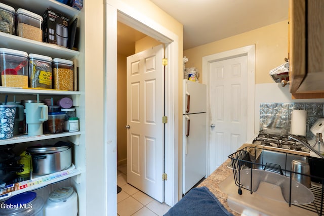 8-10 Spruce St, Rensselaer, NY 12144 - kitchen with freestanding refrigerator, tile patterned flooring, ventilation hood, and backsplash