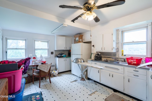 8-10 Spruce St, Rensselaer, NY 12144 - kitchen featuring freestanding refrigerator, white cabinetry, ceiling fan, tasteful backsplash, and light floors