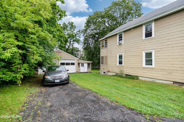 8-10 Spruce St, Rensselaer, NY 12144 - view of property exterior featuring a garage, a yard, an outbuilding, and asphalt driveway