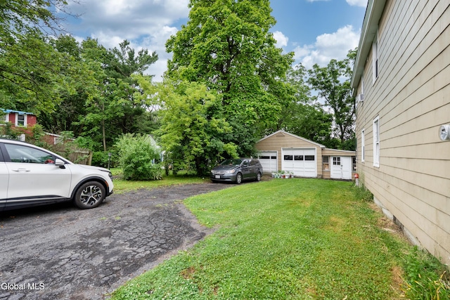 8-10 Spruce St, Rensselaer, NY 12144 - view of grassy yard featuring an outdoor structure, a detached garage, and view of scattered trees