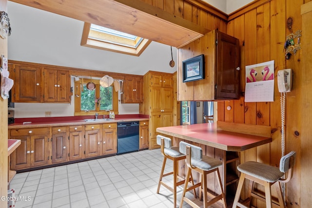 135 Willow St, Guilderland, NY 12084 - kitchen featuring black dishwasher, a skylight, brown cabinets, wood walls, and vaulted ceiling