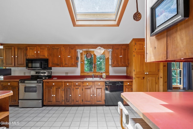 135 Willow St, Guilderland, NY 12084 - kitchen featuring black appliances, a skylight, brown cabinetry, light tile patterned flooring, and lofted ceiling