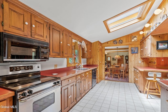 135 Willow St, Guilderland, NY 12084 - kitchen with black appliances, lofted ceiling, wood walls, a skylight, and brown cabinets