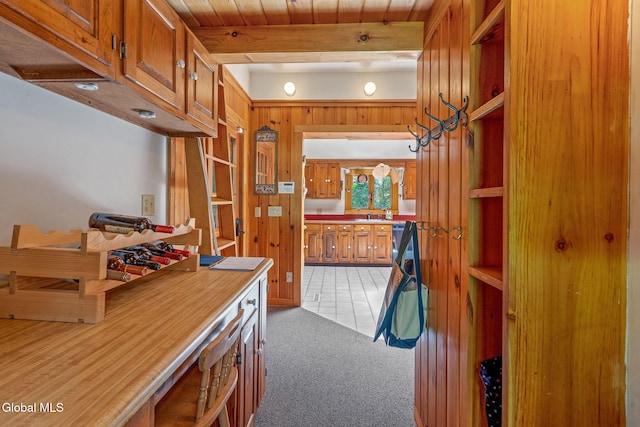 135 Willow St, Guilderland, NY 12084 - kitchen featuring brown cabinetry, light colored carpet, open shelves, wood walls, and light countertops