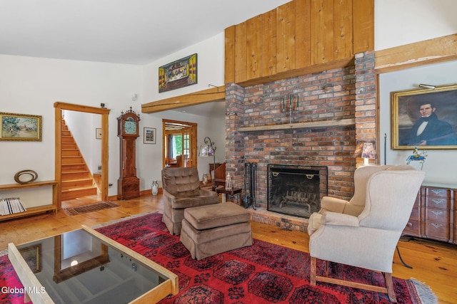 135 Willow St, Guilderland, NY 12084 - living area with hardwood / wood-style floors, a brick fireplace, and stairway